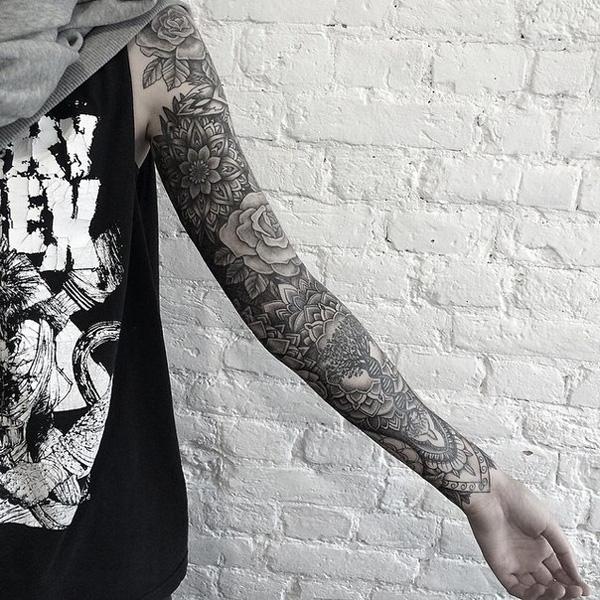 Svart og grå tatovering med blomster på full arm