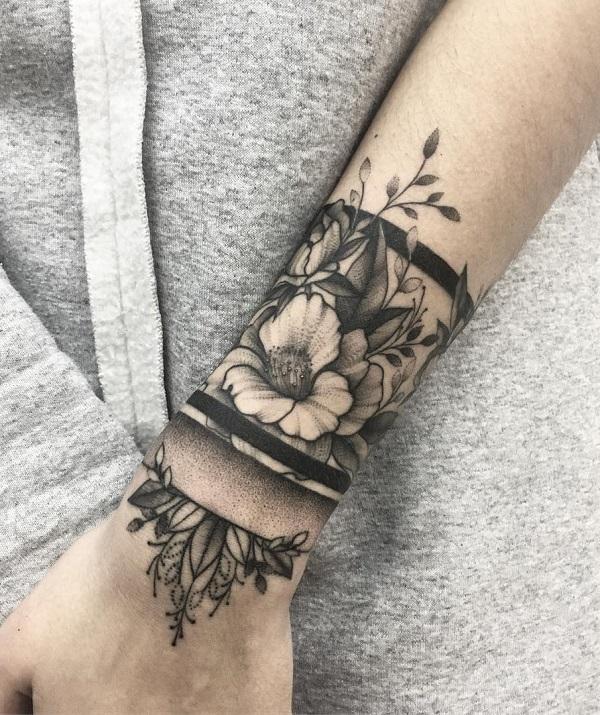 Blomstret tatovering på armbåndet på håndleddet og armen