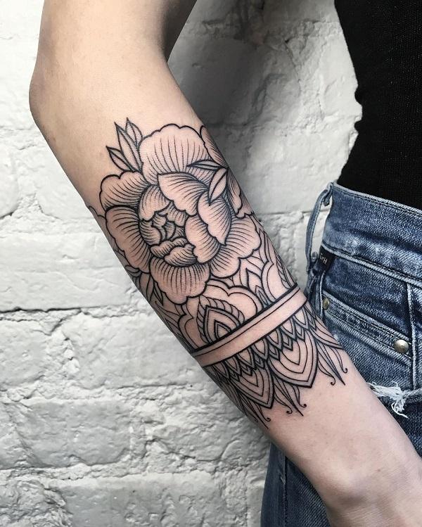 Blomst med mandana tatovering på underarmen