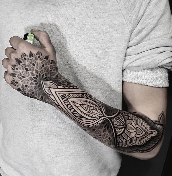 Symmetrisk mandala inspirert dotwork tatovering som strekker seg fra albue til hånd