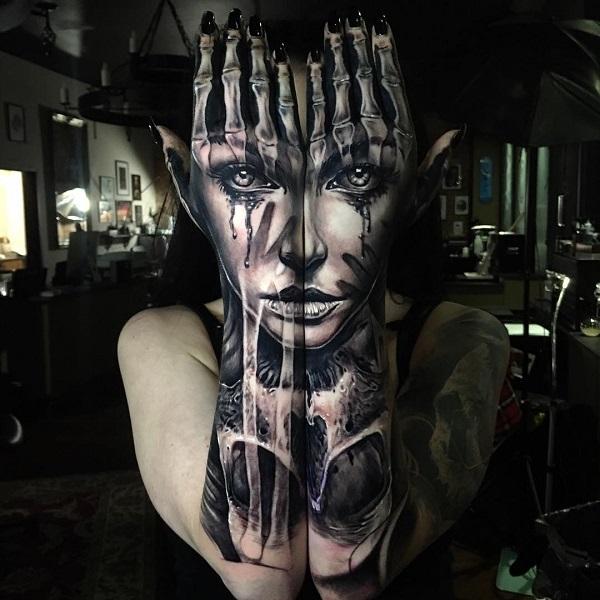 Realistiske tatoveringer på armer og hender som etterligner menneskelig ansikt