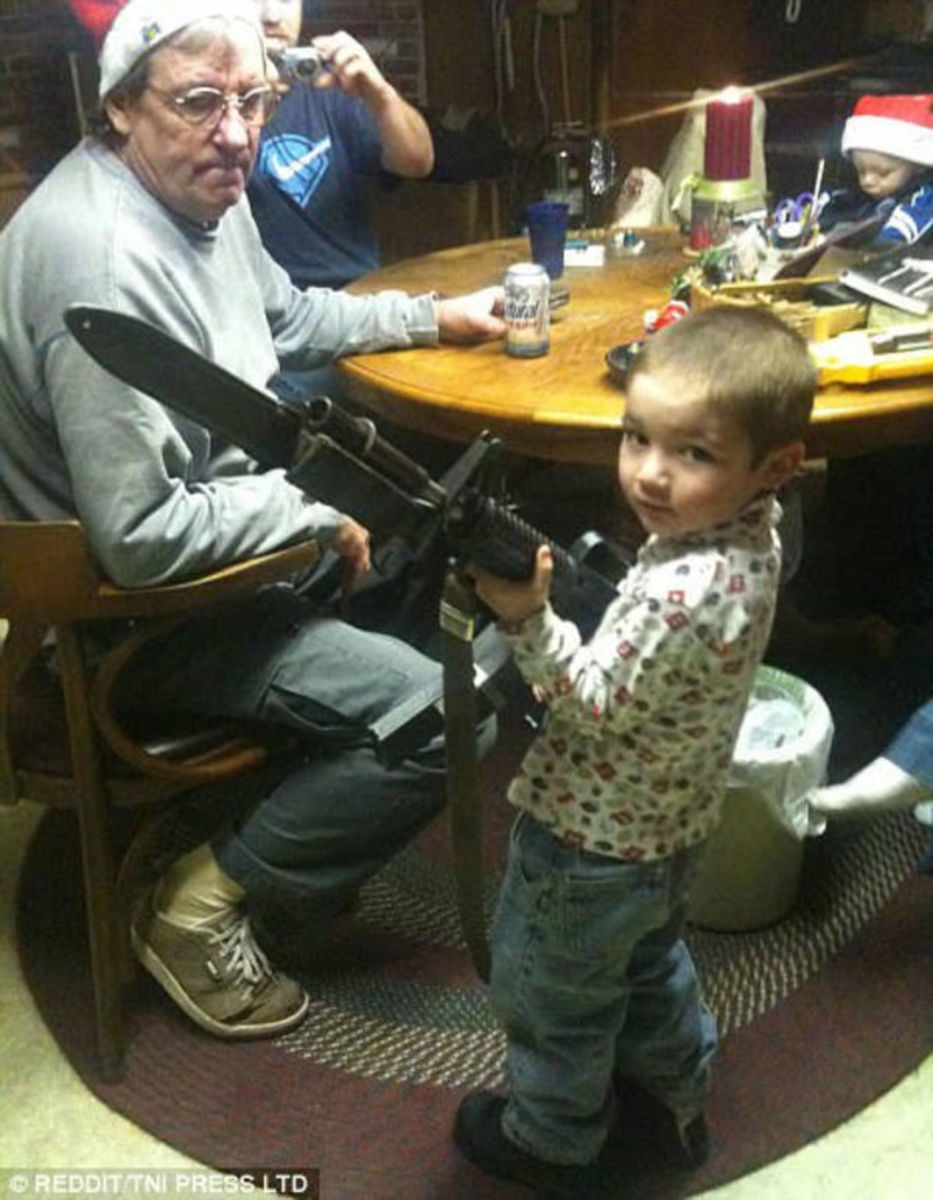 האקדח כל כך גדול והמצלמה של האב כל כך קטנה. סרוק את התמונה הזו לאיתור עוד מוזרויות.