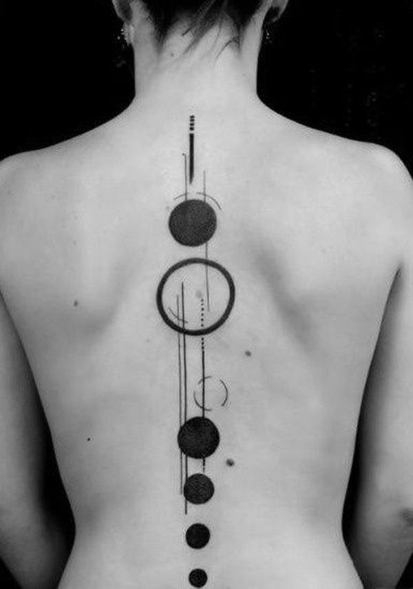 Abstrakt tatovering med prikker og sirkler som stjerner langs ryggraden