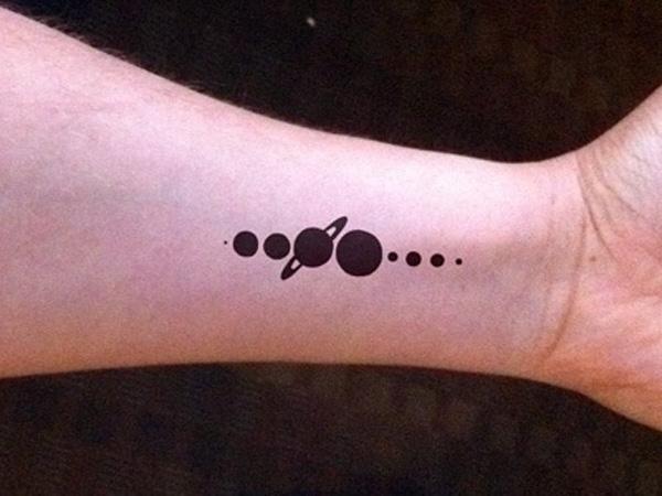 Silhuett tatovering med planeter i en rett linje på håndleddet
