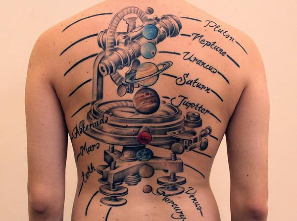 Teljes hátú tetoválás egy bolygókat szimuláló műszerrel