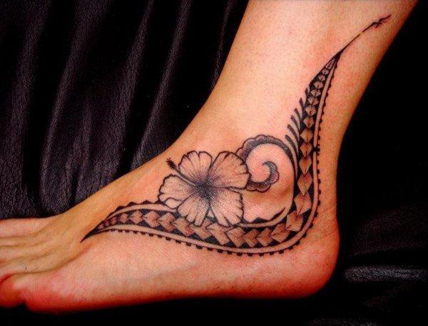 Den feminine polynesisk inspirerte tatoveringen har stil og elementer Samoan Tatau, liljeblomst, spydhoder.