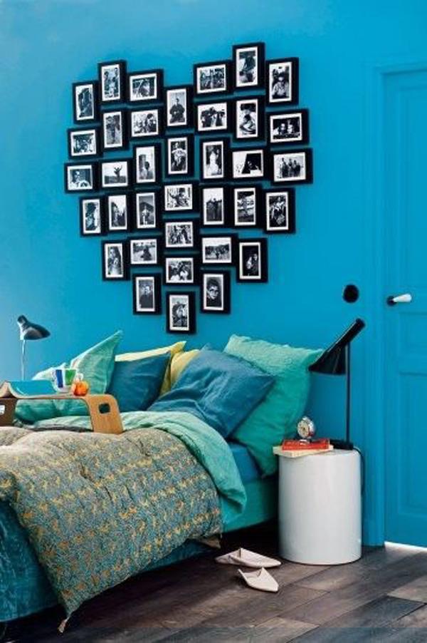 חדר שינה בצבע טורקיז עם ראש מיטה בצורת לב עשוי מסגרות תמונה