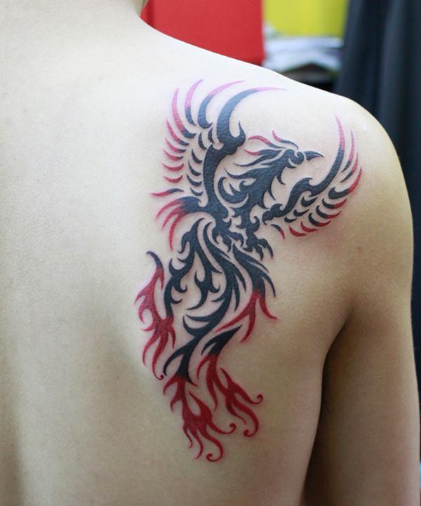 Fekete és piros tetoválás, főnix háttal törzsi stílusban