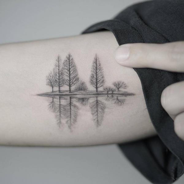 Små trær refleksjon i vann liten arm tatovering
