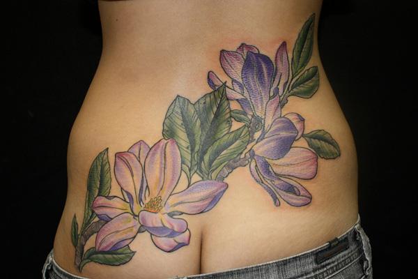 Magnólia tetoválás a hát alsó részén