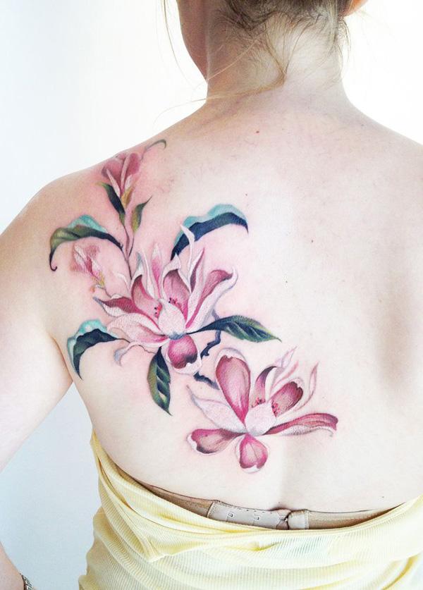 Rózsaszín magnólia virág tetoválás a hátán - nőies tetováló ötlet nőknek