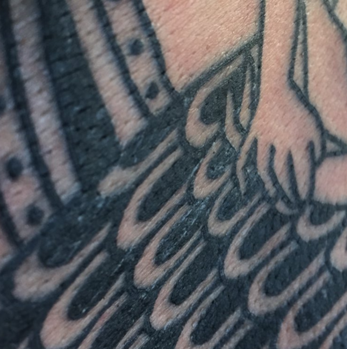 Egy közeli, folyamatban lévő felvétel a tetoválásról.