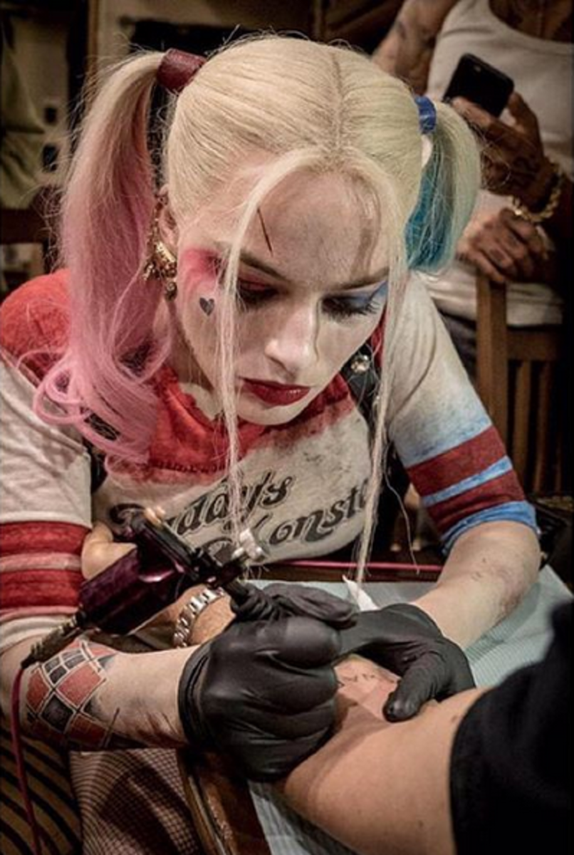 Margot Robbie (még mindig jelmezben, mint egy Harley Quinn tintával), tetoválva egyik sztártársát.