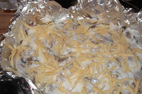 leg champignons op de vis en bestrooi met kaas