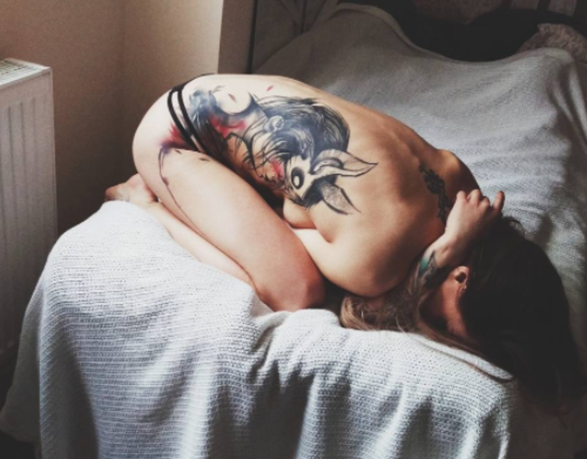 lány az ágyon oldalsó darab tetoválással