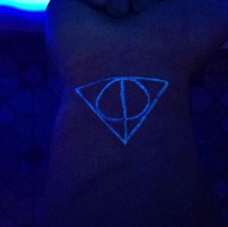 Ez a Harry Potter-rajongó másképp nézte meg a fekete fény tetoválását, és kapott egy UV-reaktív darabot, amelyet a Halál ereklyéinek jele ihletett. A tetováláson egy egyenes függőleges vonal látható, amely az Elder Wand pálcát képviseli, egy kör, amely metszi a Feltámadás kő vonalát, és a három szimbólumot körülvevő háromszög, amely a láthatatlanság köpenyét jelképezi, amelyek mindegyike csak egy speciális fekete fényben jelenik meg.