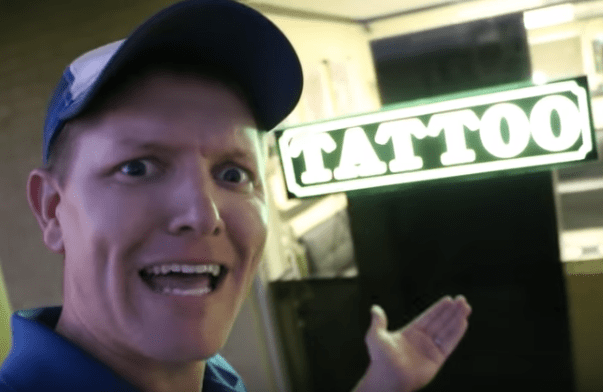 mann som står foran tatoveringssalongen