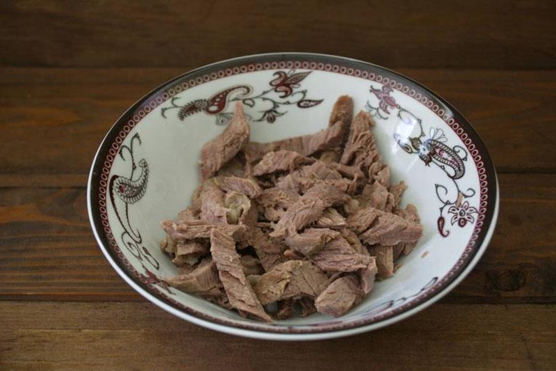 leg het gekookte vlees op een bord