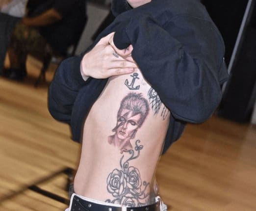 Lady GagaLady Gagas David Bowie -tatovering ble bleket 13. februar 2016, og har et portrett av sangeren Ziggy Stardust alter ego, med et lyn som blekket over ansiktet hans og en stjerne på høyre øyelokk. David Bowie -hyllest -tatoveringen, utført av kjendis -tatovøren Mark Mahoney, ligger på Lady Gagas venstre brystkasse, og ble inspirert av sangeren Aladdin Sane albumomslag.