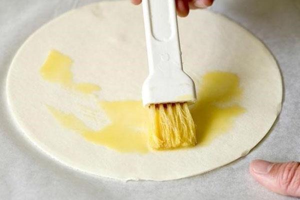 vet het uitgerolde deeg in met boter