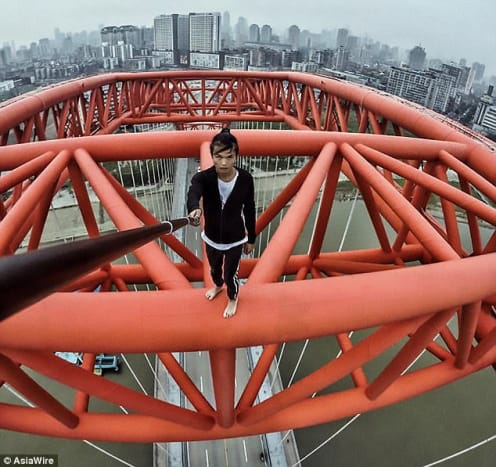 Foto via Asiawire I løpet av de siste 10 månedene har Wu skalert skyskrapere rundt Kina og utført stunts på toppen av dem, inkludert en håndarm på en arm på toppen av det 70-etasjers Sun Moon Light Plaza i Chongqing.